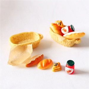 May include: Miniature food set featuring a woven basket, bread, and a jar of strawberry jam. The set includes a paper bag, a loaf of bread, and a small pastry. The LingCraftsCO logo is at the top.