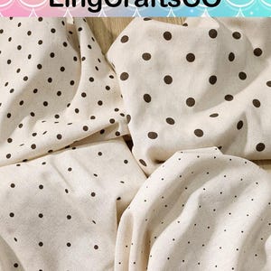 May include: Off-white fabric featuring a repeating pattern of dark brown polka dots in varying sizes. The textile is draped in folds, showcasing the texture of the material. The text LingCraftsCO is visible at the top of the image.