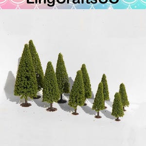 May include: A selection of miniature green model trees with brown bases. The trees are of varying sizes and shapes, with a conical form. The text "LingCraftsCO" is at the top of the image.