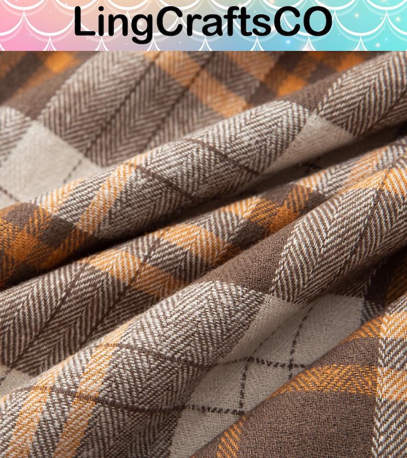May include: A fabric with a plaid pattern in shades of brown, tan, and orange. The material features a visible herringbone weave texture throughout the design, with thin dark brown lines intersecting to form a grid across the checkered surface.