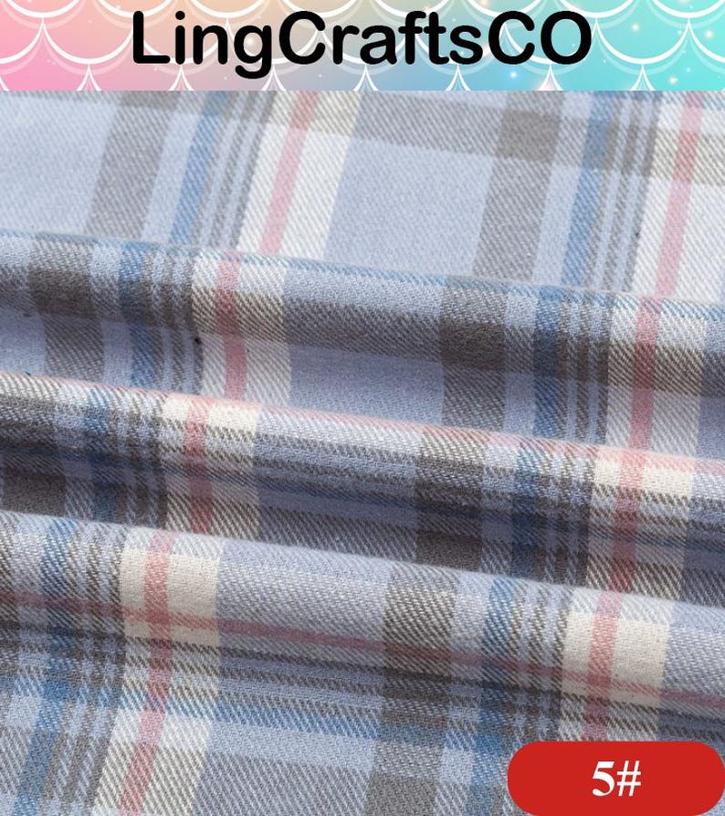 May include: A woven fabric featuring a plaid pattern in shades of light blue, white, grey, and thin pink stripes. The material is folded, creating soft horizontal drapes across the surface. The text LingCraftsCO appears at the top, and 5# is at the bottom.