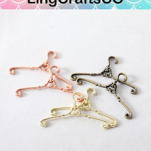May include: Four decorative metal hangers in rose gold, bronze, and gold tones. The hangers have ornate details and are arranged on a white surface. The text "LingCraftsCO" is at the top.