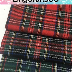 May include: Three folded pieces of fabric featuring a classic tartan plaid pattern. The top piece is primarily red, the middle piece is dark green and black, and the bottom piece is dark green. Each fabric has thin white, yellow, and blue lines.
