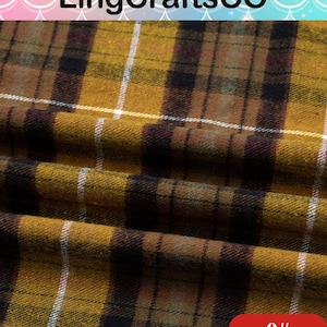 May include: A mustard yellow fabric featuring a dark brown and black plaid pattern with thin white vertical and horizontal lines. The textile has a soft, slightly fuzzy texture and is draped to show folds. The text LingCraftsCO and 9# are visible.