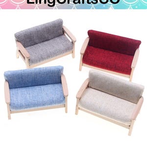 May include: Four miniature sofas in gray, red, blue, and beige. Each sofa has a wooden frame and armrests, with a textured fabric seat and back. The sofas are designed for dollhouses or miniature settings.