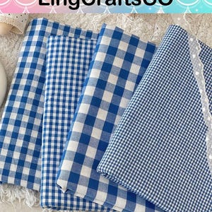 Puede incluir: Cuatro piezas de tela dobladas con patrones de cuadros vichy en azul y blanco de diferentes tama&ntilde;os. El texto LingCraftsCO es visible en la parte superior. Una pieza de tela a la derecha tiene un delicado borde de encaje blanco en el lateral.