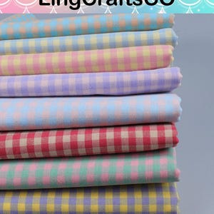 May include: A stack of folded fabric pieces featuring a gingham check pattern in various pastel and bright color combinations, including blue, yellow, pink, purple, red, green, and orange. The text LingCraftsCO is visible at the top.