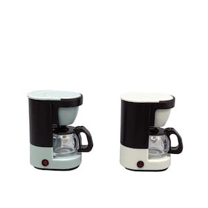 May include: Two miniature coffee makers. One is light blue, black, and white, and the other is white, black, and off-white. Each has a clear glass carafe with a black handle and a red power button. The coffee makers are designed for a dollhouse or miniature setting.