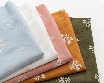 May include: Five folded pieces of fabric in light blue, white, dusty pink, mustard yellow, and olive green. Each piece features a repeating white embroidered floral sprig pattern. The text LingCraftsCO is visible at the top of the image.