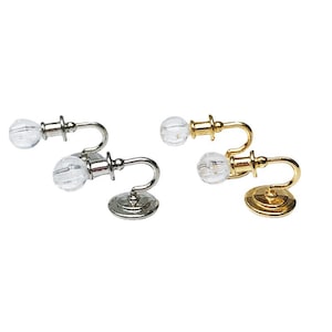 May include: Three miniature wall sconces with clear glass globes. One sconce is silver, one is gold, and one is a combination of silver and gold.