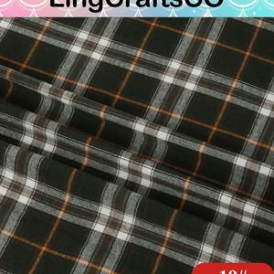 May include: A fabric featuring a dark green, white, and orange plaid pattern. The material is folded, creating visible diagonal drapes across the surface. The text LingCraftsCO is visible at the top, and the number 19# is printed in a red box.
