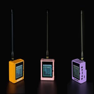 May include: Three portable electronic radio devices with long black antennas, each featuring a rectangular screen displaying text and a series of buttons below the display. The devices are coloured yellow, light pink, and light purple respectively.