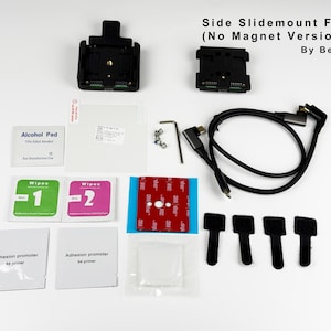 Op de afbeelding: Een kit voor een Side Slidemount voor C4 (No Magnet Version) van BearTech. De kit bevat zwarte montagebeugels, een kabel, doekjes, een alcoholdoekje, schroeven en plakpads. De tekst "Side Slidemount For C4 (No Magnet Version) By BearTech" is zichtbaar.