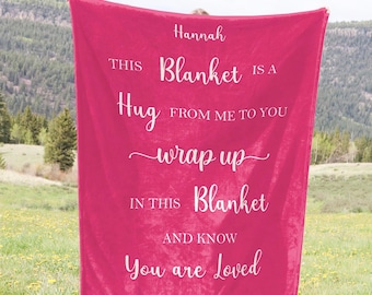 May include: A pink fleece blanket with the text "Hannah This Blanket Is A Hug From Me To You Wrap Up In This Blanket And Know You Are Loved" printed in white.