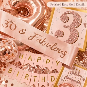 May include: Rose gold birthday decorations, including a sash that reads "30 & Fabulous", a banner that says "Happy Birthday", and a glittery number 3. The decorations are set against a backdrop of rose gold balloons and confetti.