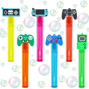 May include: Set of six colorful bubble wands shaped like video game controllers. The wands are made of plastic and have a clear tube for blowing bubbles. The controllers include a classic NES controller, a Game Boy, a PlayStation controller, an Xbox controller, a Nintendo Switch controller, and a Game & Watch.