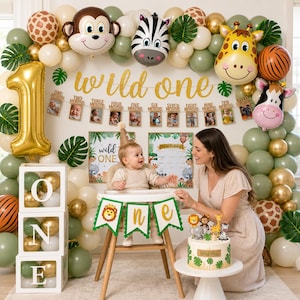 May include: A festive first birthday party scene with a 'Wild One' theme. Balloons in various shades of green, gold, and beige surround a baby in a high chair. A banner reads 'Wild One' and a cake is decorated with animal figurines.