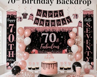 May include: A 70th birthday party setup with a black and rose gold theme. Includes a backdrop, balloons, cake, banner, and decorations. The backdrop reads "70 & Fabulous". The banner says "Happy Birthday".