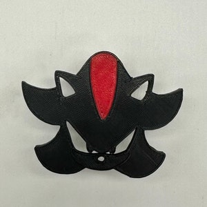 May include: Black and red 3D printed figurine of Shadow the Hedgehog from the Sonic the Hedgehog video game series.