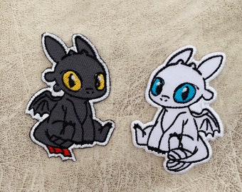 May include: Two embroidered patches of Toothless and Light Fury from the How to Train Your Dragon movie. Toothless is black with yellow eyes and Light Fury is white with blue eyes.