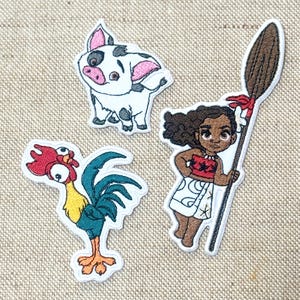 May include: Embroidered patches of cartoon characters: a white pig with black spots, a rooster with red and blue feathers, and a girl holding a spear. The patches have white borders on a tan fabric background.