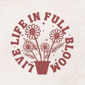 Op de afbeelding: Een rood grafisch ontwerp met de tekst "Live Life in Full Bloom" in een cirkel met een gestileerd bloemendesign in het midden. De bloemen hebben smiley-gezichten.