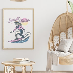 Decorative poster with a Surfing Cowgirl design, showing a cowgirl riding a surfboard with the text "Sunset Rider," perfect for home decor and wall art.