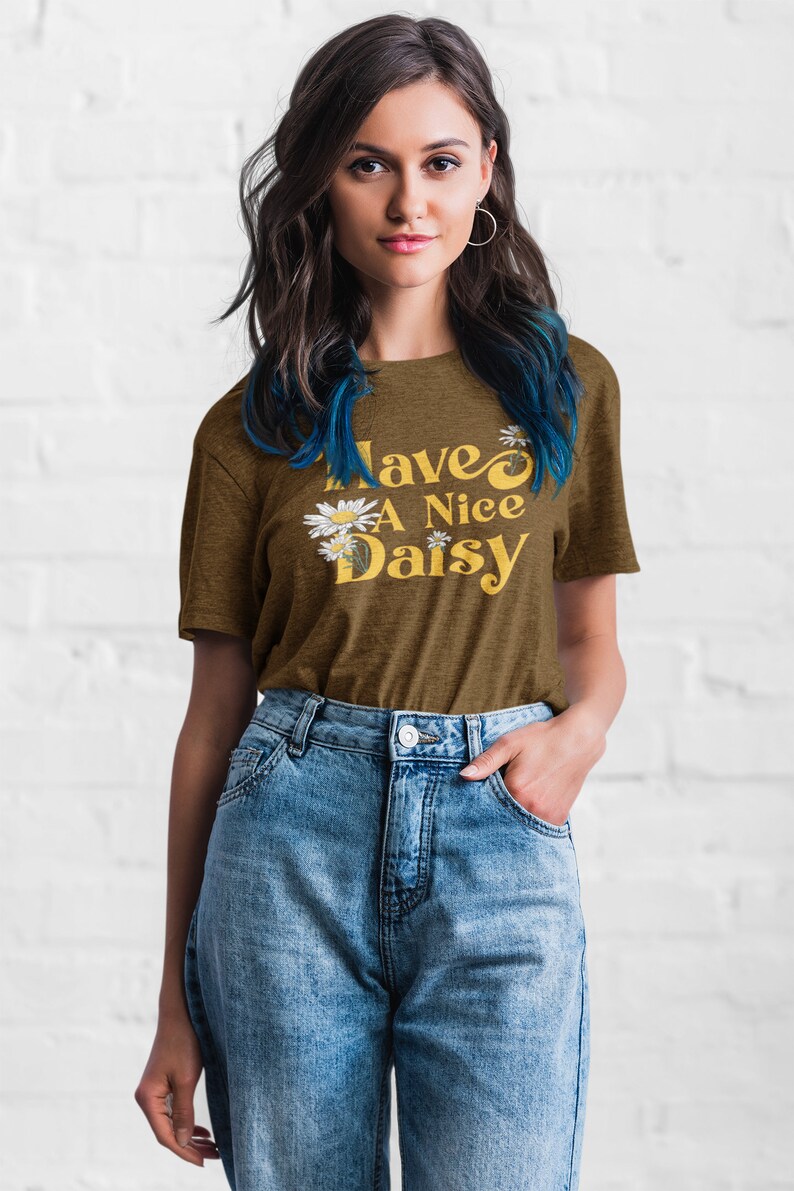 May include: A brown t-shirt with the text "Have a Nice Daisy" in yellow with white daisy flowers.