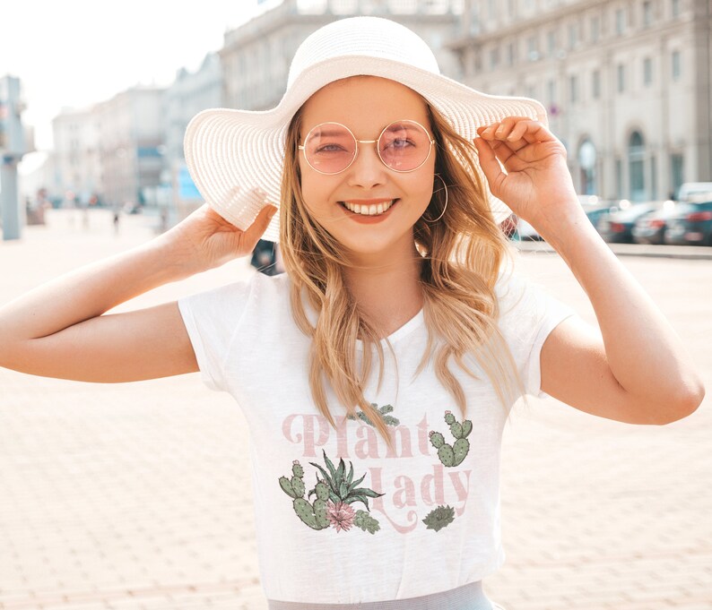 May include: A white t-shirt with a pink graphic that says "Plant Lady" with a cactus and succulent design.