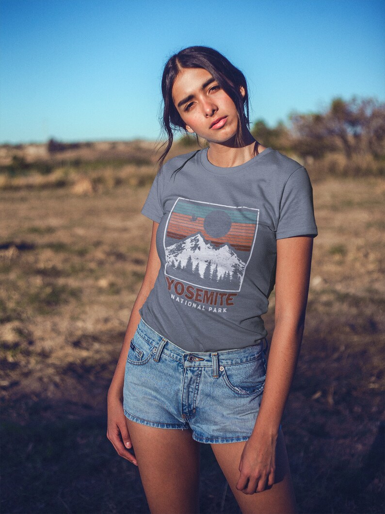 May include: A grey t-shirt with a vintage-style graphic of a mountain range and a sun with the text "Yosemite National Park".