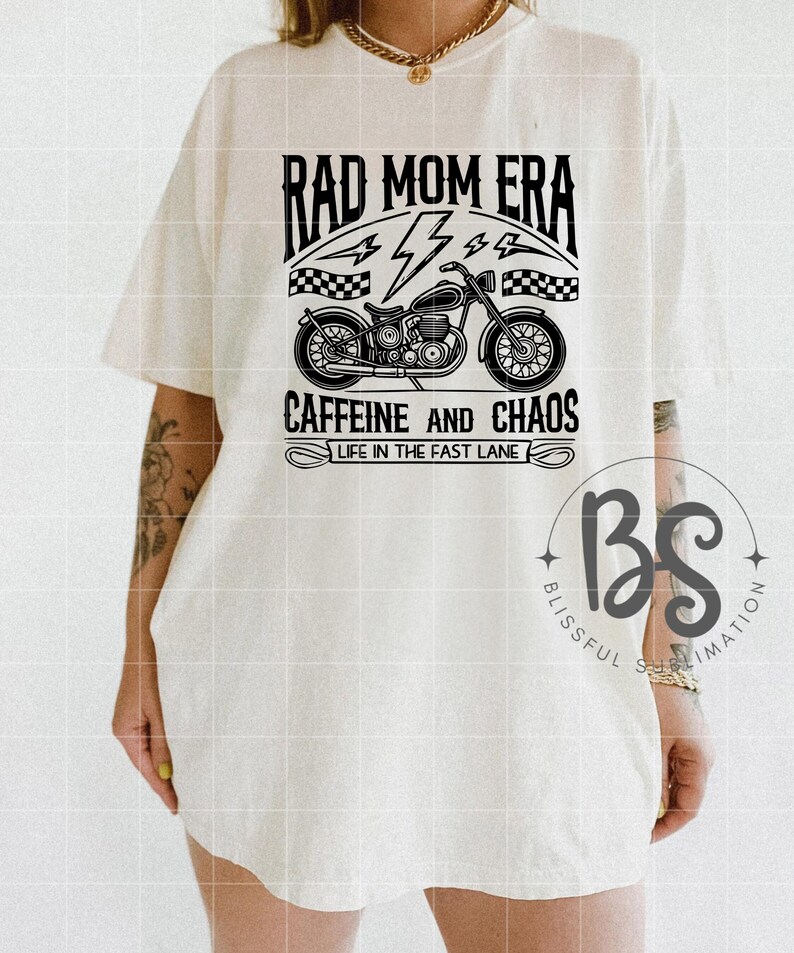 Peut inclure: T-shirt blanc avec un motif graphique noir repr&eacute;sentant une moto, des &eacute;clairs et le texte "Rad Mom Era Caffeine and Chaos Life in the Fast Lane".