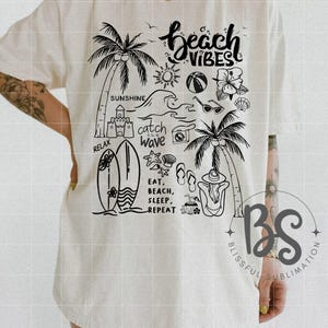 Może przedstawiać: Biały t-shirt z czarnym nadrukiem przedstawiającym palmy, deskę surfingową, okulary przeciwsłoneczne, piłkę plażową, zamek z piasku oraz tekst "beach vibes", "catch the wave", "relax" i "eat, beach, sleep, repeat".
