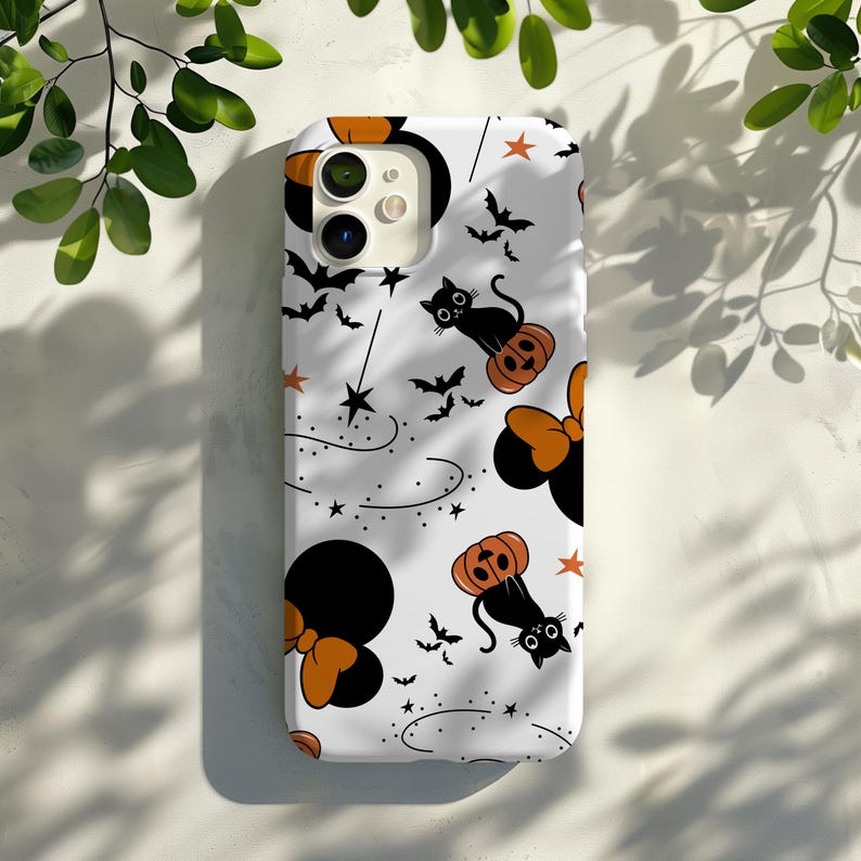 May include: White phone case with a Halloween theme. The case features black cats, pumpkins, and bows in a repeating pattern.