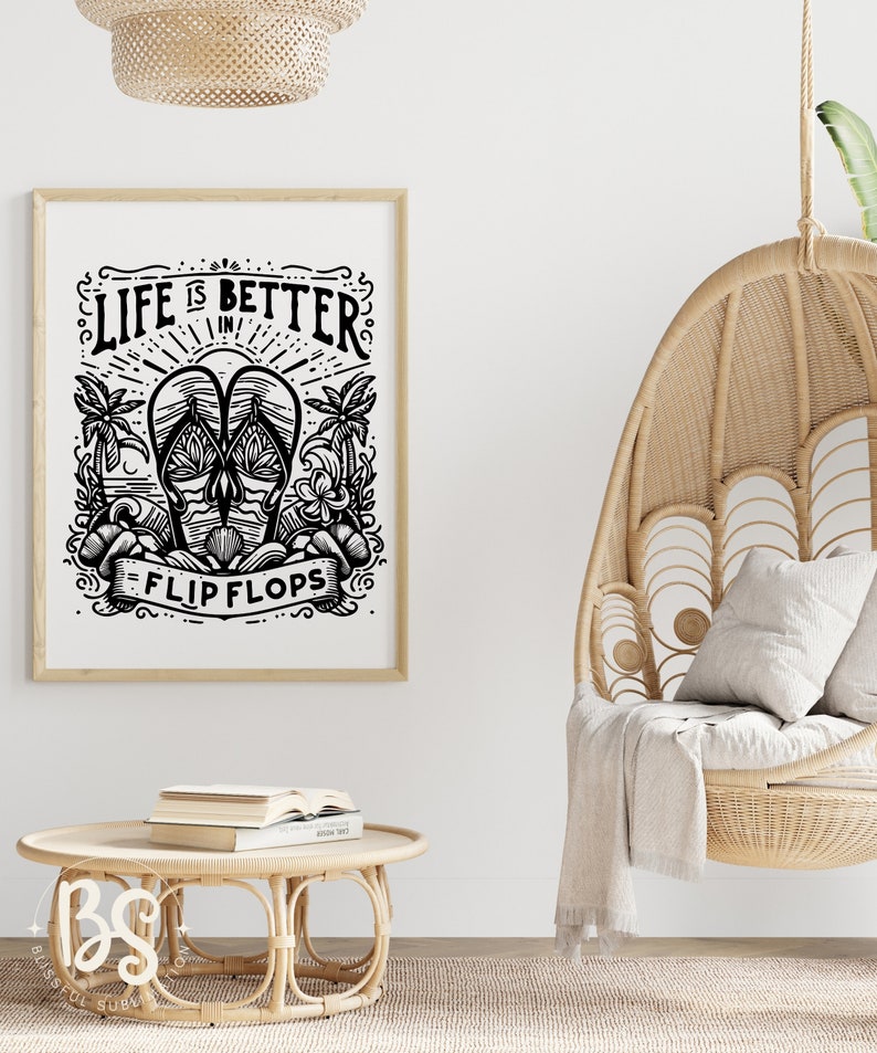 May include: Black and white illustration of flip flops with the text "Life is better in flip flops". The illustration is framed and hanging on a white wall. A wicker hanging chair with a white throw blanket is in the foreground.