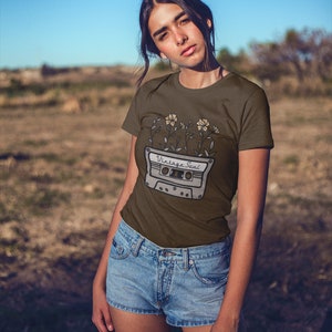 May include: A brown t-shirt with a vintage cassette tape graphic and flowers. The text on the cassette tape reads "Vintage Soul".