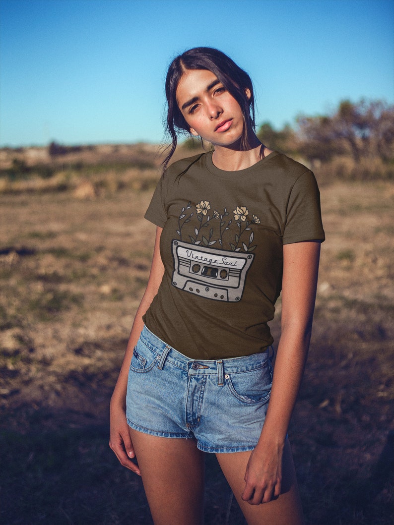May include: A brown t-shirt with a vintage cassette tape graphic and flowers. The text on the cassette tape reads "Vintage Soul".