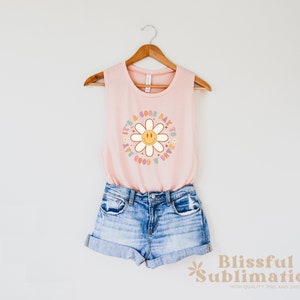 May include: A pink sleeveless tank top with a daisy graphic and the text "It's a good day to have a good day".
