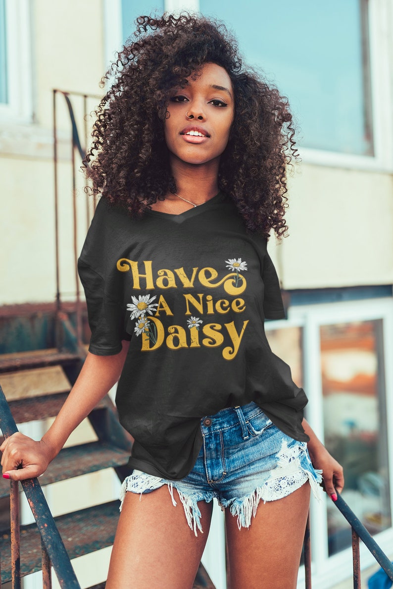 May include: A black t-shirt with a yellow and white daisy graphic and the text "Have A Nice Daisy".