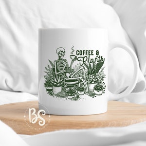 May include: White ceramic mug with a green illustration of a skeleton sitting in a chair surrounded by potted plants. The text "Coffee & Plants" is written in green above the skeleton.