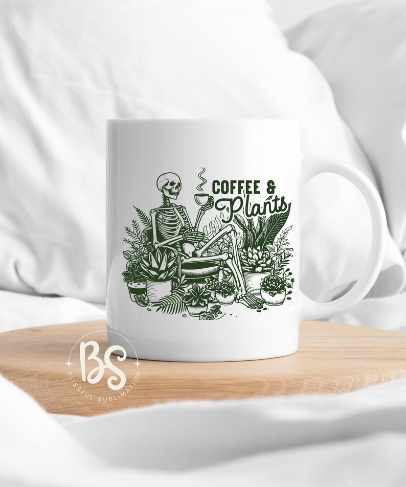 May include: White ceramic mug with a green illustration of a skeleton sitting in a chair surrounded by potted plants. The text "Coffee & Plants" is written in green above the skeleton.