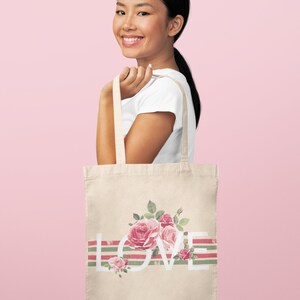 May include: A beige tote bag with a floral design and the word "LOVE" printed in white. The bag has green and pink stripes.