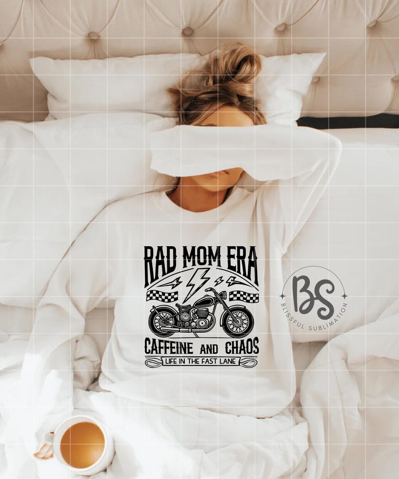 Peut inclure: Sweat-shirt blanc avec un motif graphique noir d'une moto avec le texte "Rad Mom Era", "Caffeine and Chaos", et "Life in the Fast Lane".