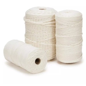 May include: Three spools of white cotton rope, each wound tightly and ready for crafting projects.