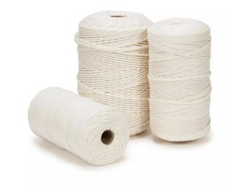 May include: Three spools of white cotton rope, each wound tightly and ready for crafting projects.