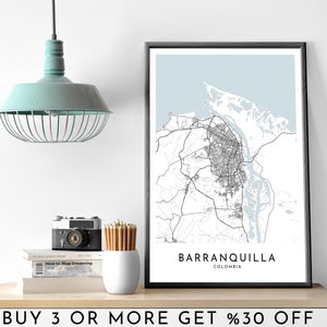 May include: A black and white city map print of Barranquilla, Colombia, with a light blue background. The print is framed in a black frame and is hanging on a white wall. The text "Barranquilla, Colombia" is printed below the map.