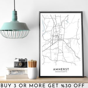 Könnte beinhalten: Ein Schwarzweiß-Kartenabdruck von Amherst, Massachusetts, in einem schwarzen Rahmen. Der Druck befindet sich auf einem Regal mit einer Kamera, Bleistiften und Büchern. Der Text "BUY 3 OR MORE GET %30 OFF" befindet sich unter dem Regal.