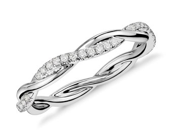 Könnte beinhalten: Ein silberfarbener Ring mit einem geflochtenen Design. Der Ring hat eine Reihe kleiner, klarer Edelsteine, die entlang einer Seite der Drehung angeordnet sind. Der Ring wird vor einem weißen Hintergrund gezeigt, um seine komplizierten Details hervorzuheben.