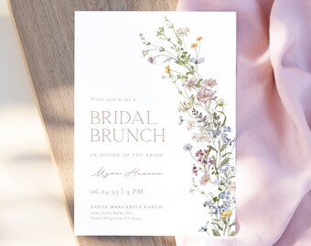 May include: A white invitation card with a floral border. The text reads "Please join us for a Bridal Brunch in honor of the bride Myra Hanian 06.24.23 | 3 PM Santa Margarita Ranch Santa Margarita, CA"
