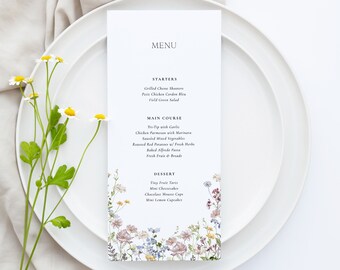 Può includere: Un menu bianco con un design floreale sulla metà inferiore. Il menu elenca le opzioni di antipasti, piatti principali e dessert. Il testo sul menu recita: "MENU", "STARTERS", "Grilled Cheese Showers", "Petite Chicken Gordon Bleu", "Field Green Salad", "MAIN COURSE", "Tri-Tip with Garlic", "Chicken Parmesan with Marinara", "Sautéed Mixed Vegetables", "Roasted Red Potatoes w/ Fresh Herbs", "Baked Alfredo Pasta", "Fresh Fruit & Breads", "DESSERT", "Tiny Fruit Tarts", "Mini Cheesecakes", "Chocolate Mousse Cups", "Mini Lemon Cupcakes", "LO BEHOLD".