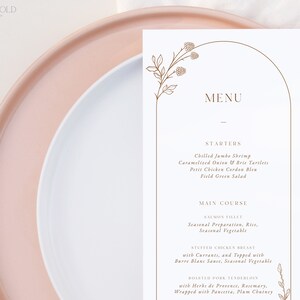 May include: A white menu card with a brown floral design and an arched border. The menu lists starters and main courses, including chilled jumbo shrimp, caramelized onion and brie tartlets, petit chicken cordon bleu, field green salad, salmon fillet, stuffed chicken breast, and roasted pork tenderloin.